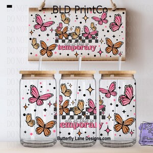 May include: Three glass tumblers with bamboo lids and straws, decorated with pink and brown butterflies, stars, and the text "all this is temporary." A matching wooden sign hangs above. The design is repeated on the sign.