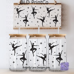 May include: A set of three clear glass tumblers with bamboo lids and straws, each decorated with black silhouettes of ballerinas and stars. A matching wooden sign with the text "BLD PrintCo" and ballerina designs hangs above the tumblers. The website "Butterfly Lane Designs.com" is also visible.