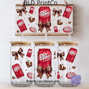 May include: Clear glass tumblers with bamboo lids, featuring a Dr. Pepper design with leopard print bows, hearts, and soda cans. The design is also on a wooden sign. The text "BLD PrintCo" and "Butterfly Lane Designs.com" are visible.
