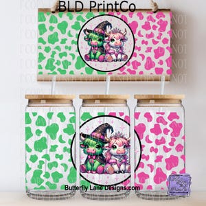 May include: A set of glass tumblers with bamboo lids and straws, featuring a cow-themed design. The tumblers have a green and pink cow print pattern. The center tumbler has a circular graphic with two cartoon cows wearing witch hats and crowns. A wooden sign with the same design hangs above.