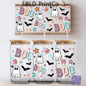May include: A Halloween-themed set featuring three glass tumblers with bamboo lids and a decorative sign. The tumblers and sign are adorned with the word "BOO", ghosts, bats, stars, and candy corn. The sign reads "BLD PrintCo".