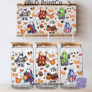 May include: A set of three glass tumblers with wooden lids and straws, each decorated with Halloween-themed superhero ghost designs. The designs include Batman, Iron Man, Captain America, and others, along with pumpkins and the word "Boo."