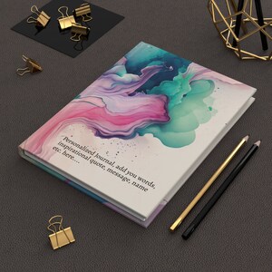 May include: A personalized journal with a white cover and abstract watercolor design in shades of pink, blue, and green. The text on the cover reads "Personalized Journal, add you words, inspirational quote, message, name etc. here..."