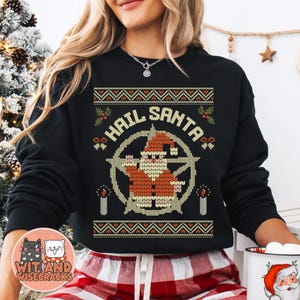 May include: Black Christmas sweater with a white and yellow knit pattern. The sweater features a cartoon Santa Claus with a pentagram behind him and the text "Hail Santa".