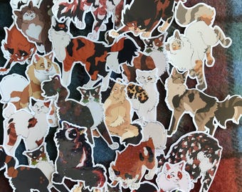 May include: A collection of colorful cat stickers featuring various breeds and poses. The stickers are printed on white paper and have a glossy finish.