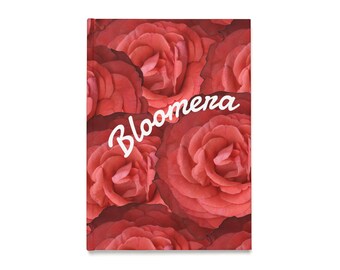 以下が含まれることがあります： 赤いバラをあしらったフローラルデザインのジャーナル。表紙は花の重なり合う画像でいっぱいです。「Bloomera」という文字がジャーナルの上部に白いスクリプトで書かれています。