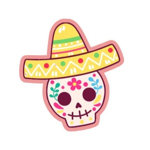 Puede incluir: Una colorida pegatina de calavera de azúcar del Día de Muertos. La calavera es blanca con diseños florales y de hojas, con un sombrero amarillo con detalles rojos, verdes y blancos. La pegatina tiene un borde rosa.