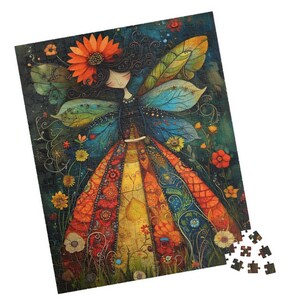 Könnte beinhalten: Ein farbenfrohes Puzzle mit einer Fee mit einer Sonnenblume im Haar und gemusterten Flügeln. Die Fee trägt ein Kleid mit leuchtend orangefarbenen, roten und gelben Bahnen. Das Puzzle ist vor einem dunklen Hintergrund mit Blumen angeordnet.