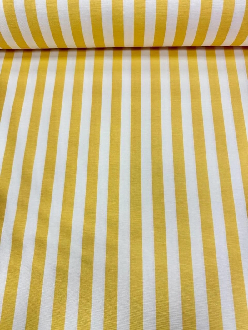 May include: Yellow and white striped fabric. The fabric features vertical stripes of a bright yellow color alternating with white stripes. The fabric is rolled up at the top, showing the texture and pattern of the material.