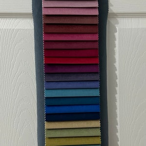 May include: A fabric swatch book with 20 different fabric samples in various colors, including white, beige, pink, red, blue, green, brown, and gray.