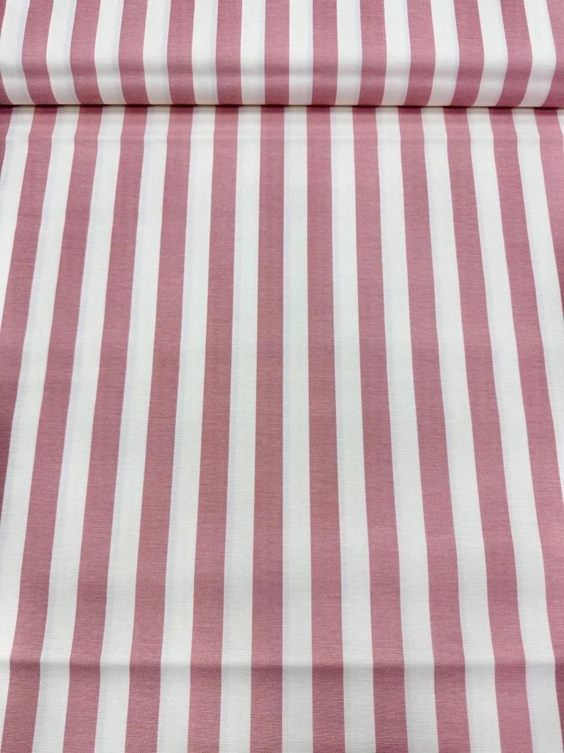 May include: Fabric with a repeating pattern of vertical stripes in white and dusty rose. The stripes are evenly spaced and run the length of the fabric. The fabric appears to be folded over at the top.