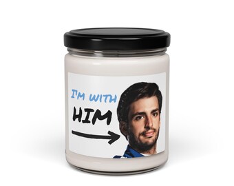 May include: A white candle jar with a black lid. The jar has a white label with the text "I'm with HIM" and an arrow pointing to the right. A man's face is on the label.