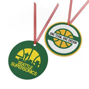 Pode incluir: Dois ornamentos redondos com fitas vermelhas. Um é verde com o logótipo amarelo dos Seattle SuperSonics e o Space Needle. O outro é branco com um gráfico de basquetebol verde e amarelo e o texto ONE TEAM, ONE DREAM em letras pretas.