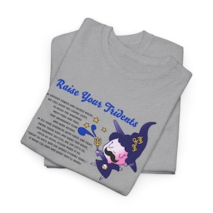 Peut inclure: Deux t-shirts gris pliés, le supérieur présentant un personnage de dessin animé avec un trident et le texte "Raise Your Tridents". Le design comprend des étoiles et du texte sur les Mariners.
