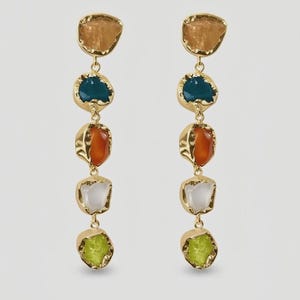 May include: A pair of long, dangling earrings with a gold-tone metal setting. Each earring features five irregularly shaped, colourful stones: amber, teal, orange, white, and lime green. The stones are connected by small gold chains.