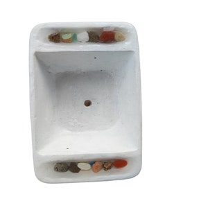 Puede incluir: Macetero rectangular blanco con dos filas de piedras decorativas de colores incrustadas en los bordes superior e inferior.