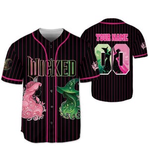 Pu&ograve; includere: Maglia da baseball nera con gessati e dettagli rosa. La parte anteriore presenta la parola "WICKED" in un font stilizzato, insieme alle sagome di due personaggi. Il retro ha spazio per un nome e un numero, con sagome di personaggi.