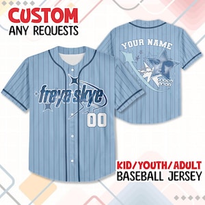 May include: Light blue baseball jersey with pinstripes, featuring the name "freya skye" and the number "00". The back of the jersey has the text "YOUR NAME" and a graphic. The jersey is available in kid, youth, and adult sizes. The top reads "CUSTOM ANY REQUESTS".