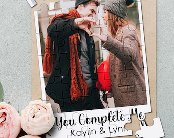 Könnte beinhalten: Ein Puzzle mit einem Foto eines Paares, das mit seinen Händen ein Herz formt. Das Puzzle befindet sich auf einem braunen Hintergrund mit dem Text "You Complete Me Kaylin & Lynn".
