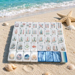 Könnte beinhalten: Ein Set aus weißen, rechteckigen Mahjong-Spielsteinen, die in einem Raster angeordnet sind und farbenfrohe Illustrationen zum Thema Ozean mit Muscheln, Korallen, Meerestieren sowie chinesischen Schriftzeichen zeigen.
