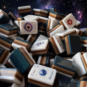 May include: A collection of rectangular Mahjong tiles featuring a layered design with white, brown, and dark blue sections. The tiles display various space-themed illustrations, including a black hole labelled Joker, a planet labelled 1 Crak Mercury, and Red.