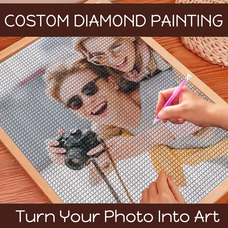 May include: A close-up of a diamond painting in progress, featuring a photo of two people. The image shows a man and a woman wearing sunglasses, with the man holding a camera. The text "CUSTOM DIAMOND PAINTING" is at the top of the image, and the text "Turn Your Photo Into Art" is at the bottom.