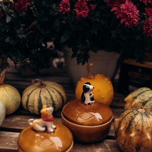 Artisan pottery keepsake box featuring adorable ceramic dog decoration on orange-brown crackled lid with blue ceramic cup base, cozy autumn home accent piece for jewelry organization