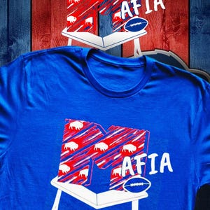 Buffalo Bills Mafia custom t shirt.  Mtv influenced, letter M crashing on top of table.  Royal blue color shirt. Next Level branded tee.