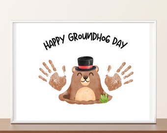 Peut inclure: Une carte blanche avec le texte "Happy Groundhog Day" en lettres noires. Un dessin animé de marmotte portant un chapeau haut de forme noir avec une bande rouge sort d'un trou dans le sol. Deux empreintes de mains brunes sont de chaque côté de la marmotte.