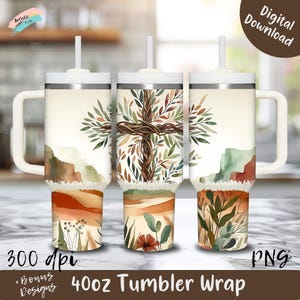 Peut inclure: Trois gobelets de 1,18 litre avec des poignées et des couvercles blancs. Chaque gobelet présente un motif aquarelle d'une croix faite de branches et de feuilles. Le motif comprend un paysage aux couleurs chaudes et le texte "40oz Tumbler Wrap".