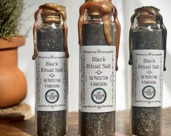 May include: Three small glass bottles filled with black ritual salt. Each bottle is sealed with a wax top and has a label that reads "Black Ritual Salt" and "For Protection & Banishing".