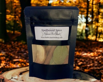 May include: A black resealable pouch with a clear window showing the contents. The pouch is labeled "Spellbound Spice" and "Simmer Pot Blend" with the website "www.ThePeculiarPathShop.com". The pouch is sitting on a tree stump in a forest setting.