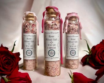 May include: Three small glass bottles filled with pink rose-scented bath salts. Each bottle has a pink wax seal and a label that reads "Rose Ritual Salt for Self-Love & Compassion" with a logo that says "The Peculiar Pate".