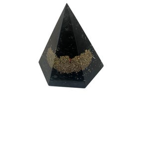 May include: Black pyramid with gold accents. The pyramid is made of resin and has a smooth, polished finish.