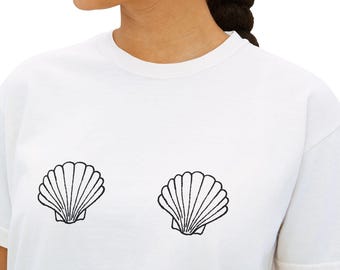 May include: White t-shirt with two black seashell designs. The shells are printed on the front. The top has short sleeves and a round neckline.