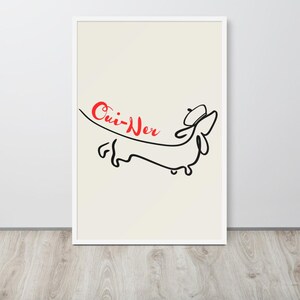 May include: Framed art print featuring a minimalist line drawing of a dachshund wearing a beret. The word "Oui-Ner" is written in red cursive above the dog. The artwork is set against a cream background within a white frame.