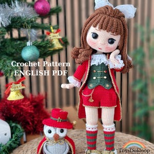 May include: A crocheted doll and owl, both in festive outfits. The doll is dressed in a red coat, shorts, and a green vest. The owl wears a red hat and cape. The text "Crochet Pattern ENGLISH PDF" is visible.