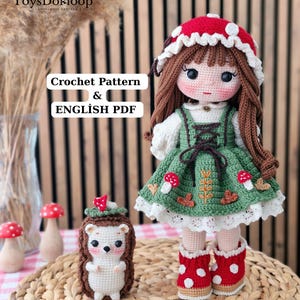 May include: A handmade crochet doll with brown hair, wearing a red mushroom-patterned hat, a green dress with mushroom and leaf embroidery, and red boots with white spots, accompanied by a small crochet hedgehog and two small mushroom figurines.