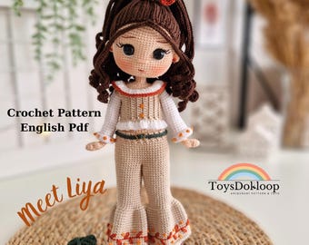 May include: A handmade crochet doll named Liya, with brown hair and a bohemian style outfit. The doll is wearing a cream-colored top and pants with orange accents. The text "Crochet Pattern English Pdf" and "Meet Liya" are visible.