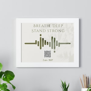 May include: White framed print with the text "Breathe Deep Stand Strong" in green text. A stylized sound wave graphic is below the text with a QR code below the graphic. The text "Custom Text" is below the QR code.