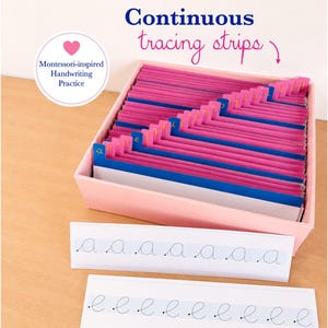 Peut inclure: Un ensemble de cartes d'entraînement à l'écriture dans une boîte rose clair. Les cartes présentent des lettres cursives continues avec des onglets bleus étiquetés de a à z. Deux bandes blanches avec les lettres a et e répétées sont devant.