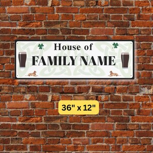 Peut inclure: Panneau rectangulaire en m&eacute;tal avec l'inscription "House of FAMILY NAME" en noir, sur fond vert clair avec des tr&egrave;fles, des n&oelig;uds celtiques et des illustrations de verres &agrave; bi&egrave;re et de chiens. Le panneau mesure 91 cm x 30 cm.