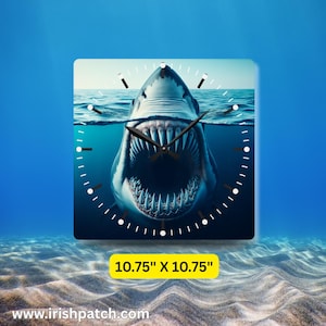 May include: Square wall clock featuring a shark with an open mouth underwater. The clock face shows the shark's teeth and the ocean. The clock measures 10.75 inches by 10.75 inches.