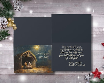 May include: A Christmas card with a dark grey cover and a painting of the Nativity scene. The card's interior features a Christmas message in elegant gold script. The card is decorated with festive elements.