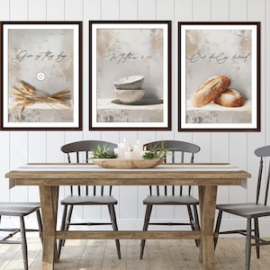 May include: Three framed prints with a rustic theme. The left print features wheat stalks and the text "Give us this day". The middle print features two bowls and the text "For in Matthew 6:11". The right print features two loaves of bread and the text "Our daily bread".
