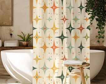 May include: A retro-style shower curtain with a cream background and a repeating pattern of starburst shapes in orange, yellow, teal, and green. The curtain hangs in a bathroom with a white tub, wooden stools, and a large potted plant.