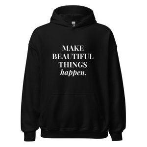 May include: Black hooded sweatshirt with the text "MAKE BEAUTIFUL THINGS happen." printed in white on the front.