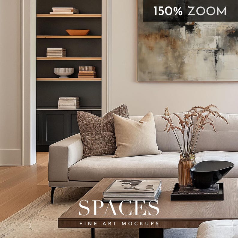 May include: A light gray sofa with two pillows, one brown and one beige, sits in a living room with a coffee table and a vase of dried flowers. The coffee table has a stack of books and a black bowl on top. The text "SPACES FINE ART MOCKUPS" is printed on the coffee table.