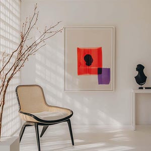 Puede incluir: Un interior moderno con una silla tejida con patas negras, una pintura abstracta enmarcada con formas rojas y moradas, y una escultura de busto negro sobre una mesa blanca. La habitaci&oacute;n tiene un dise&ntilde;o minimalista con luz natural.