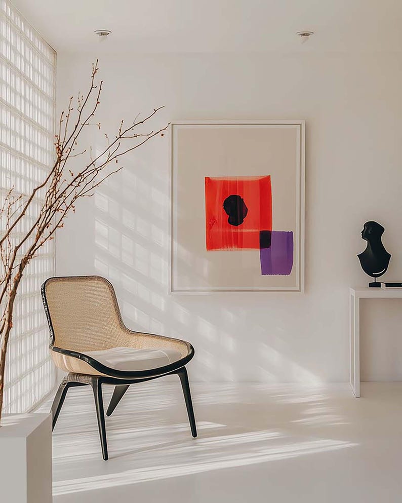 Puede incluir: Un interior moderno con una silla tejida con patas negras, una pintura abstracta enmarcada con formas rojas y moradas, y una escultura de busto negro sobre una mesa blanca. La habitaci&oacute;n tiene un dise&ntilde;o minimalista con luz natural.